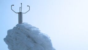 Thies CLIMA Ultrasonic 2D Anemometer (US2D) im Hintergrund auf dem Mount Washington, wo es unter extremen Bedingungen wie -43,9°C und Windgeschwindigkeiten bis zu 408 km/h eisfrei bleibt. Der US2D-Sensor ist mit beheizten Ultraschallwandlern ausgesta